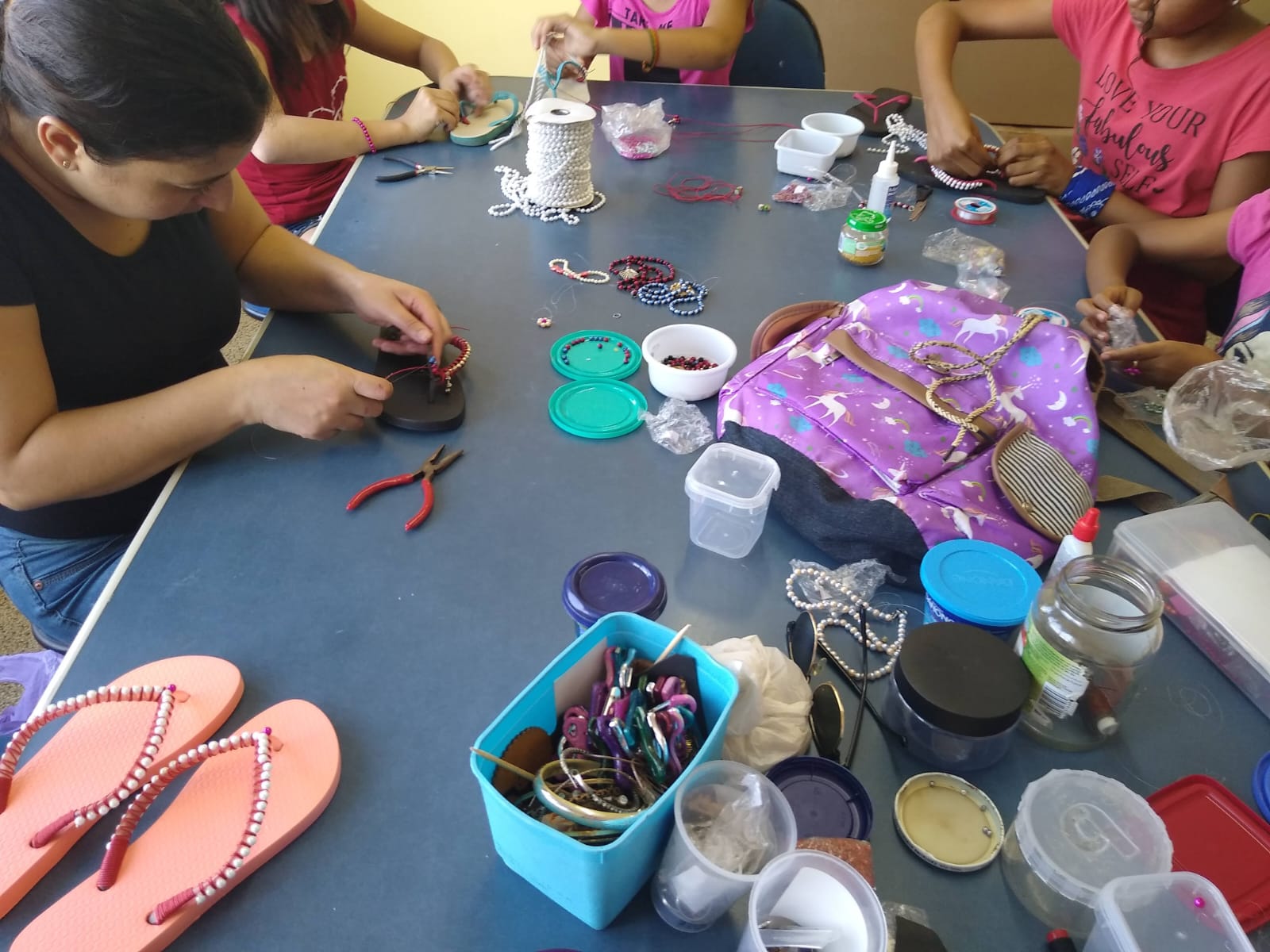 Participantes trabalhando com materiais e adornos em uma oficina de artesanato